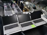 Plusieurs ordinateurs portables sont alignés sur une table dans une pièce.