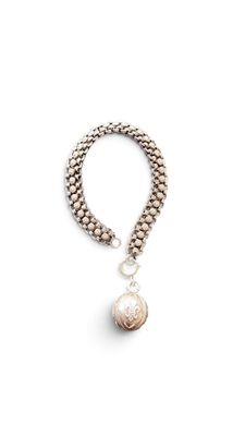 a close up of a bracelet with a pearl on it