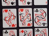 des cartes à jouer ornées de motifs rouges et noirs, posées sur une table