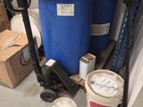 un fût bleu posé à côté d'un seau bleu sur une palette dans un garage
