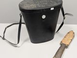 un seau noir contenant un couteau et un porte-couteau, posé sur une table