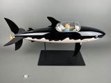 une maquette en noir et blanc d'un requin posée sur un socle