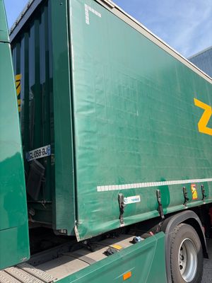 un semi-remorque vert garé sur le parking