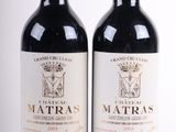 deux bouteilles de vin rouge posées l'une à côté de l'autre sur une surface blanche