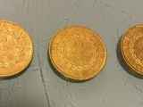 three gold coins sitting on top of a table next to each other
