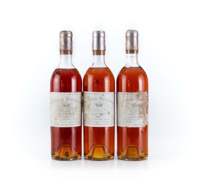 trois bouteilles de vin posées les unes à côté des autres sur une surface blanche