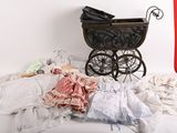 une poussette et une pile de vêtements sur un lit