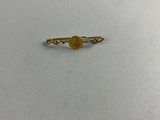 une bague en or surmontée d'une pierre jaune