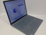 an open laptop computer sitting on top of a white table