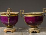 une paire de vases violets et dorés munis d'anses, posés sur une table