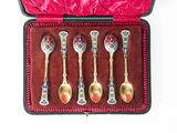 five spoons in a case with a red velvet lining