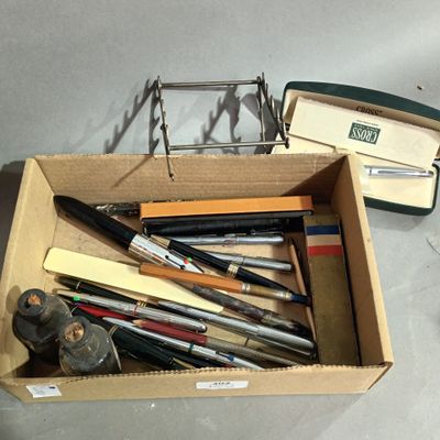 many pens and pencils in a box on the table