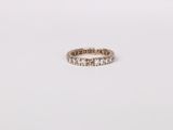 a close up of a diamond eternity ring on a white surface