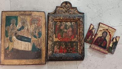 two old religious paintings are sitting on the floor next to each other
