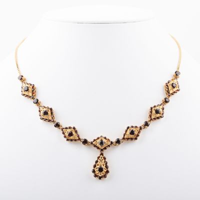 a gold and black necklace on a mannequin neck