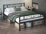 a bed with a metal frame and a green blanket