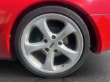 a close up of a red car ' s tire on the street