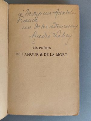 un vieux livre sur lequel on voit des inscriptions, posé sur une surface bleue
