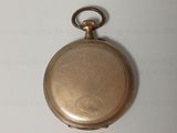an antique gold pocket watch with a chain hanging from it ' s side