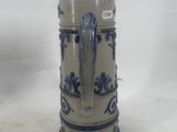 a blue and white vase with a handle on it