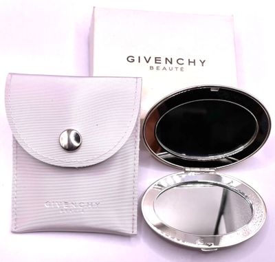 a compact mirror and a case on a white table