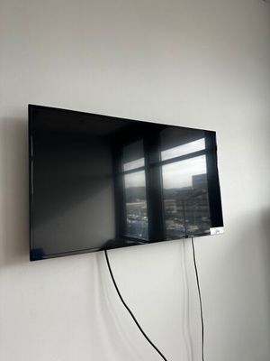 un téléviseur à écran plat fixé au mur d'une pièce