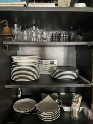 de nombreuses assiettes et verres sur les étagères de la cuisine