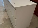 une commode blanche au milieu d'une pièce