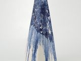un vase bleu et blanc posé sur une surface blanche