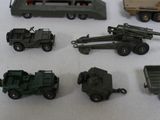 many toy army vehicles and trucks on a table