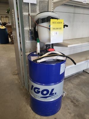 un fût bleu sur lequel est accrochée une pancarte, posé dans un garage