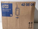 une boîte en carton sur laquelle est représenté un distributeur de savon liquide
