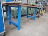 a blue table with a wooden top in a warehouse