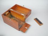 a small wooden box with a small piece of wood in it