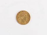 a close up of a gold coin on a white surface