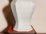 un vase blanc posé sur une table en bois