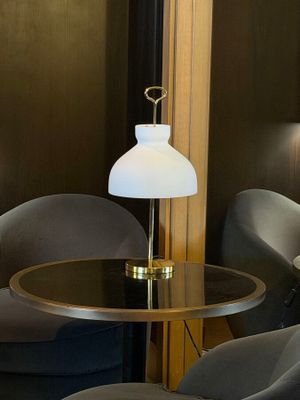 two chairs and a table in a room with a lamp on top of it