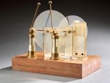 une petite maquette de machine à vapeur posée sur un socle en bois