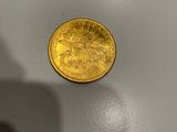une pièce d'or posée sur une surface blanche