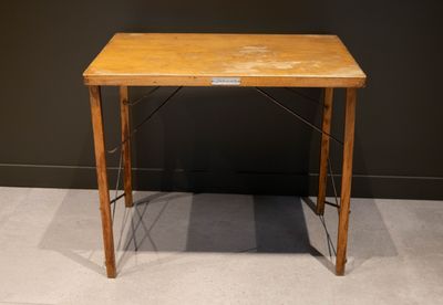 une petite table en bois sur laquelle est posé un panneau