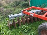 a tractor with a plow attached to it in the grass