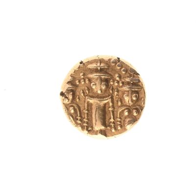 gros plan d'une pièce d'or sur une surface blanche