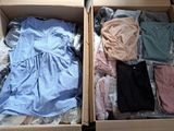 two boxes of clothes that are sitting on the floor