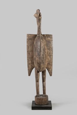an image of a wooden sculpture of a bird on a stand