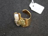 an image of a gold and pearl ring with a tag on it
