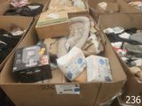 Plusieurs cartons de vêtements pour bébés et de couches sont empilés les uns sur les autres