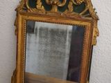 a mirror sitting on top of a wooden table next to a wall