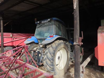 a tractor that is parked inside of a barn