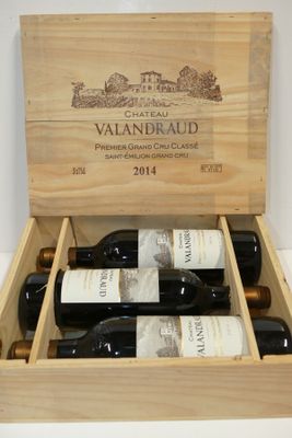 des bouteilles de vin se trouvent dans un coffret en bois sur une table