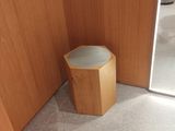 a small wooden stool in the corner of a bathroom